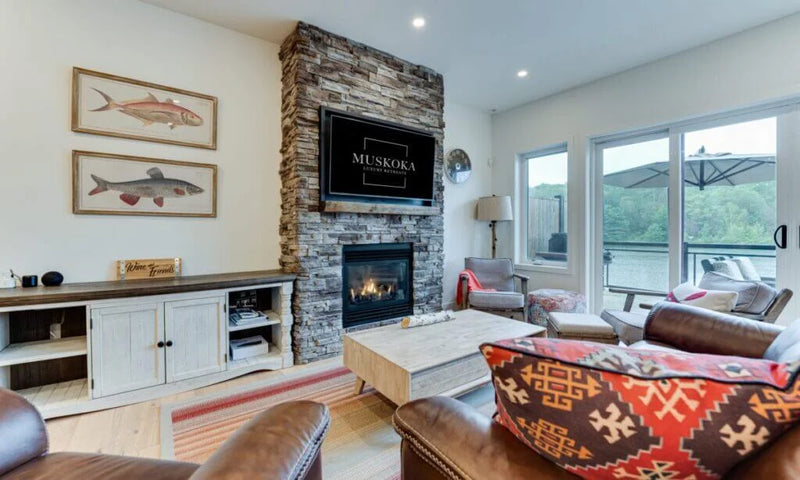 Living room with stone fireplace, television, and comfortable seating.
