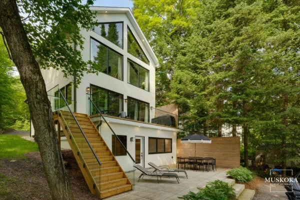 Modern house with glass windows and a staircase in a wooded area